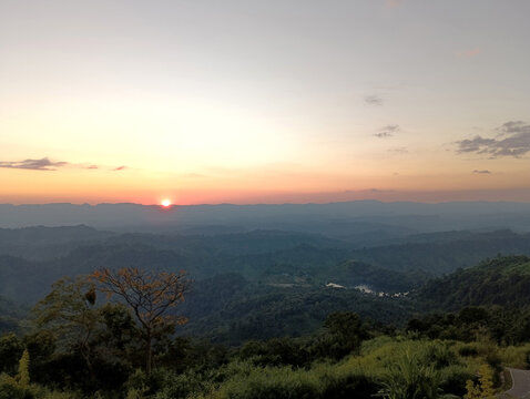 Majestic sunrise over rolling hills creates peaceful landscape scene
