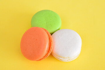a bunch of Colorful Macarons on a Bright Yellow Surface