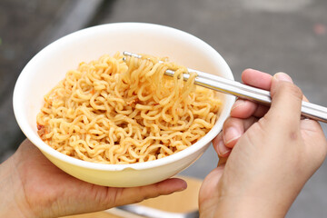 Spicy instant noodles bowl eating and hand