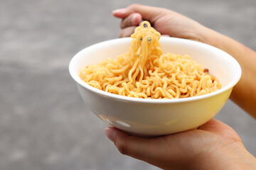 Spicy instant noodles bowl eating and hand