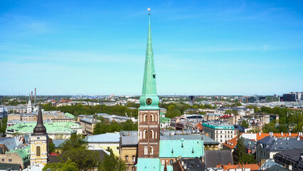 Drone panorama of Riga&rsquo;s historic skyline with St. James Cathedral spire in Latvia's capital rising against a clear blue sky, capturing summer light and architectural elegance.