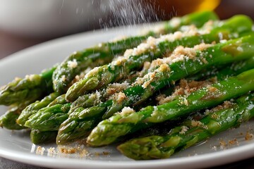 Fresh green asparagus spears sautéed with parmesan cheese and seasonings on white plate, showcasing healthy vegetable side dish for gourmet meal preparation.