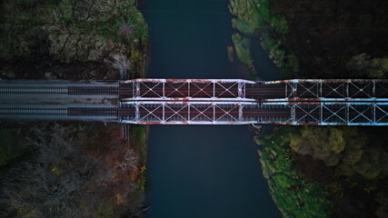 Aerial top-down view of an old metal railway bridge over a river