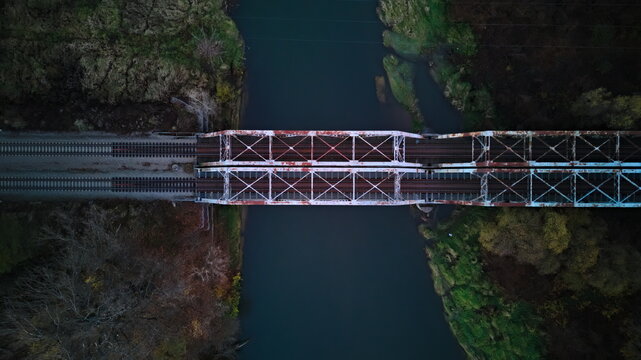 Aerial top-down view of an old metal railway bridge over a river