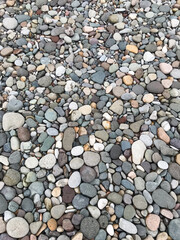 Assortment of rounded pebbles in varying sizes creating a textured surface. Nature background, geological rock study, abstract design, garden pathways and decorative landscaping