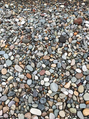 Assortment of rounded pebbles in varying sizes creating a textured surface. Nature background, geological rock study, abstract design, garden pathways and decorative landscaping