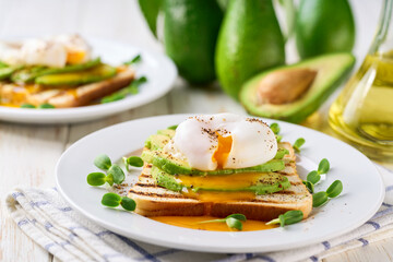 Breakfast with poached egg toast with avocado, vegetarian food.Healthy sandwich with avocado and poached eggs.