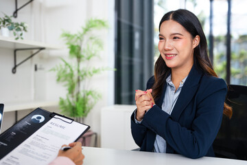 Attractive young businesswoman in a job interview with a corporate personnel manager who is reading...