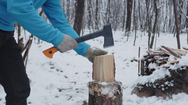Chop pine wood with an axe in a winter forest while enjoying bushcraft activities