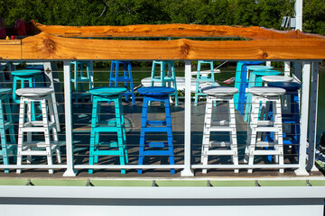 colorful blue and white stools in outdoor cafe bar on sunny day