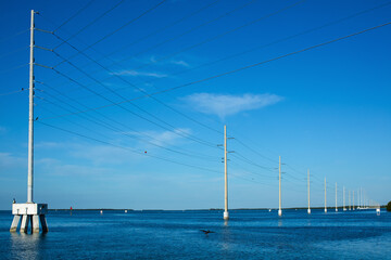 tall high voltage power lines in a row over water