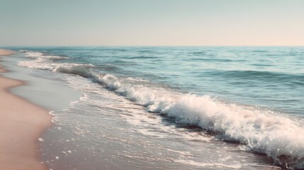 Peaceful ocean wave gently breaking on a tranquil sandy shore at dusk.