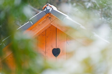 Wooden Cabin Facade with Heart-Shaped Vent in Winter