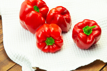 red bell pepper on a white towel on the table. Bulgarian juicy pepper on a light texture
