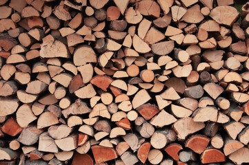 harvested chopped firewood stacked together. wooden brown texture