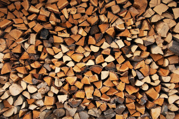 harvested chopped firewood stacked together. wooden brown texture