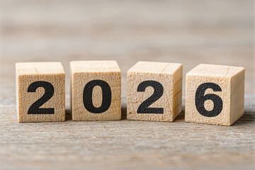 Wooden block year countdown 2026 on rustic wood surface, closeup still life with neutral background and hopeful celebratory mood
