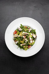Fresh avocado and feta salad with arugula, cherry tomatoes and balsamic drizzle