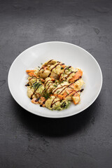 Warm cauliflower salad with broccoli and carrots, dill and balsamic drizzle in white bowl