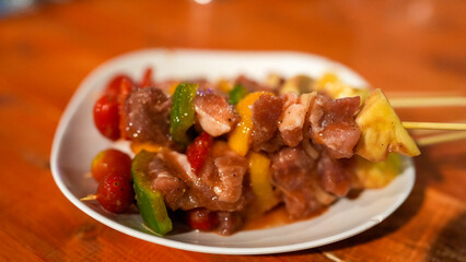 Delicious Skewered Meat with Fresh Vegetables and Fruits on a Plate Highlighting Colorful Culinary Presentation