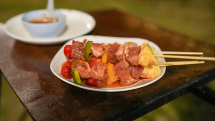 Grilled meat skewers with colorful vegetables and pineapple served on a white plate, perfect for summer barbecues and outdoor gatherings