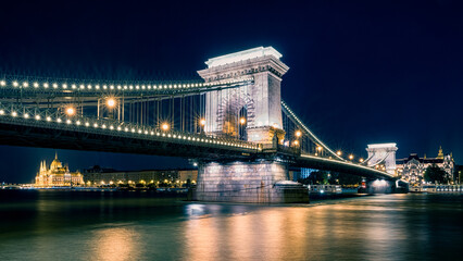 Night view of the Chain Bridge in Budapest with illuminated architecture and Parliament Building along the Danube River