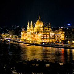Obraz premium Illuminated Hungarian Parliament Building reflecting on the Danube River in Budapest at night