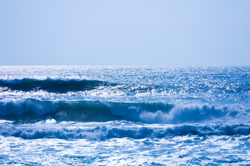 A beautiful seascape in blue tones. Ocean waves and sea foam against a backdrop of blue water