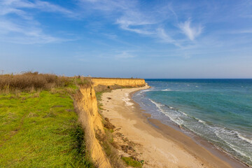 Landscape with the wild beach with a cliff from 23 August, Constanta County - Romania. Steep, yellowish cliffs and turquoise sea waters