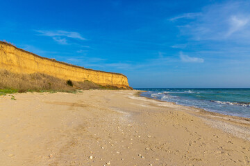 Landscape with the wild beach with a cliff from 23 August, Constanta County - Romania. Steep, yellowish cliffs and turquoise sea waters