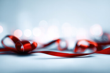 Red ribbon bow decoration festive blurred background celebration shiny elegant soft focus holiday. Red ribbon and bow decoration with blurred festive lights background creating elegant and joyful
