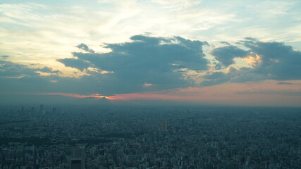The panoramic city view from the top of the skyscraper building with the sunset sky as background