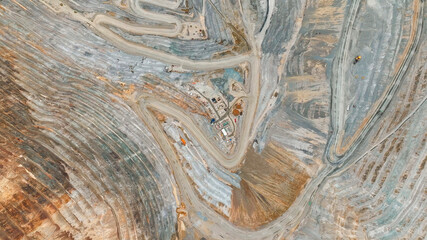 Aerial view of an open-pit mine with closed and remediated benches and mineral extraction platforms