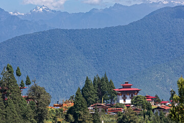 A monastery and small vaille on the highs over Punakha, and Himlayas peaks in the background