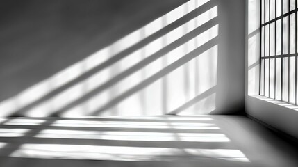 An interior scene of an empty room with a large window casting dramatic diagonal light and shadow patterns across the walls and floor. The lighting is bright an