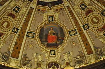 Fototapeta premium A detailed view of the ornate ceiling inside the Auditorium of Universidad Complutense. Classical figures and symbols, with a painting of Queen Isabel I. 