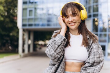 Fototapeta premium Young woman enjoying music with headphones in urban environment