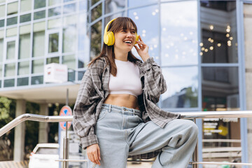 Fototapeta premium Young woman enjoying music listening with yellow headphones