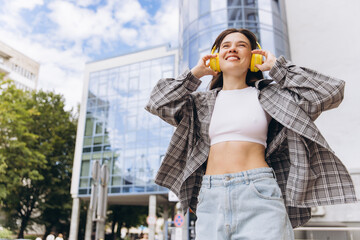 Fototapeta premium Woman enjoying music using headphones in urban city