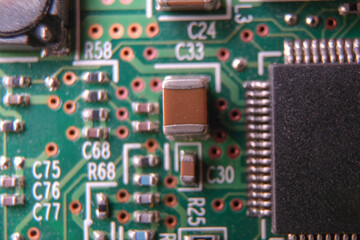 Surface mount technology capacitor on the electronic board. Selected focus.