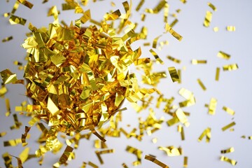 Dramatic golden confetti burst in a controlled studio environment and sparkling light