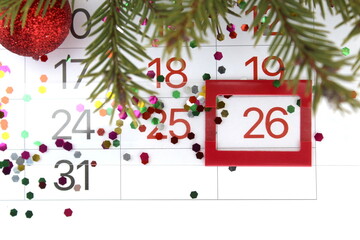 There is a paper calendar on the table with a reminder of the Christmas holiday.