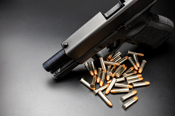 .22 ammunition and automatic gun on black background