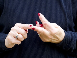 A pair of hands signing the vowel letter 'I' in British Sign Language.BSL.Communication.Hearing Impaired.
