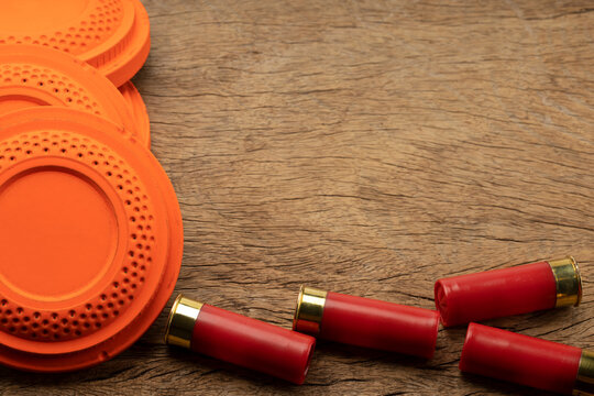 Clay disc flying targets and shotgun bullets on wooden background ,Clay Pigeon target