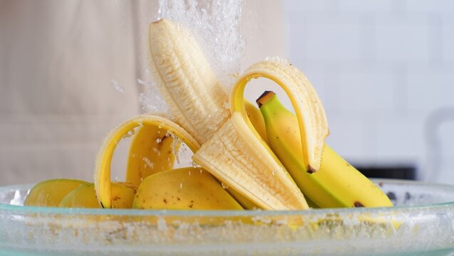 Banana eruption captured with peeled fruit spewing water and splash motion