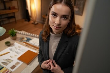 Designer at a desk reviewing sketches and color swatches with focused expression.