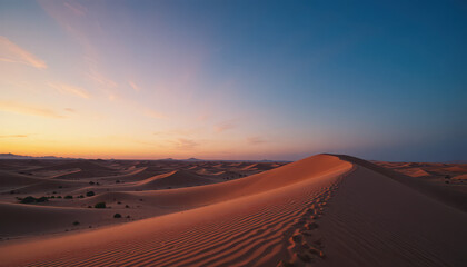 Sand dunes stretching under a vibrant sunset sky