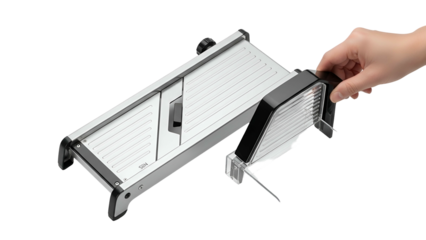 A hand holds a mandoline slicer, ready to cut. It is made of metal and plastic