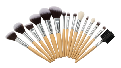 Array of assorted makeup brushes with wooden handles and black/tan bristles on black backdrop
